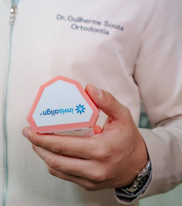 Dr. Guilherme Sousa, Invisalign Doctor, com caixa de alinhadores Invisalign